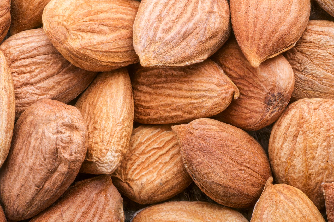 A detailed close-up of unpeeled almonds showcasing their texture and earthy brown tones.